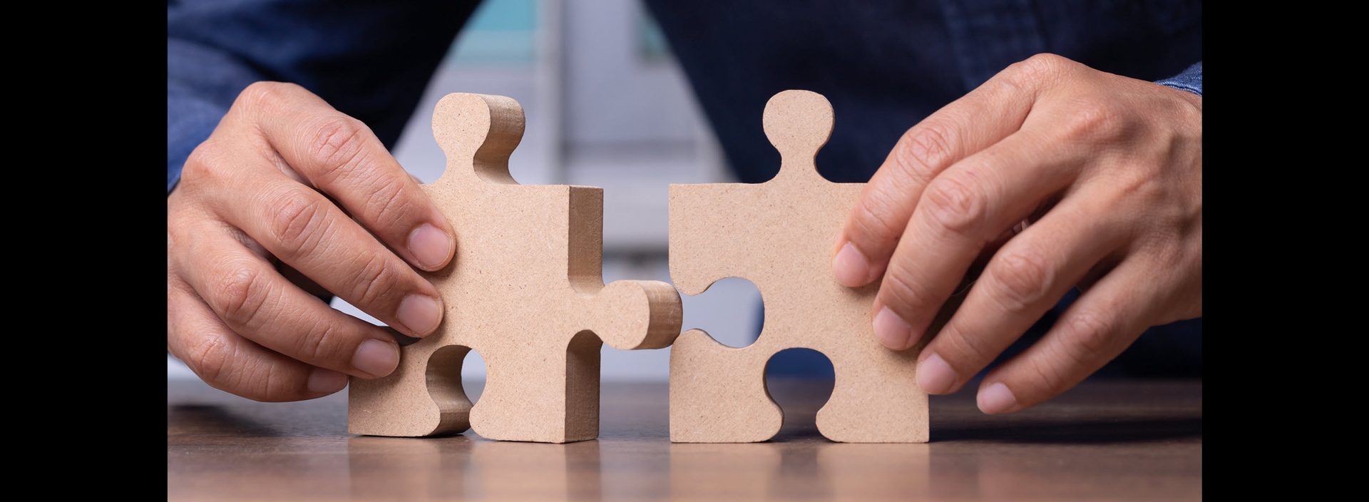 Two hands joining the last pieces of a puzzle, representing a husband and wife reconciling